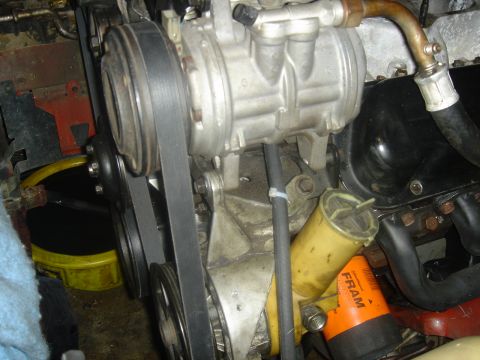 1986 Ford Mustang - Close-up view of engine components including the AC compressor and belts.