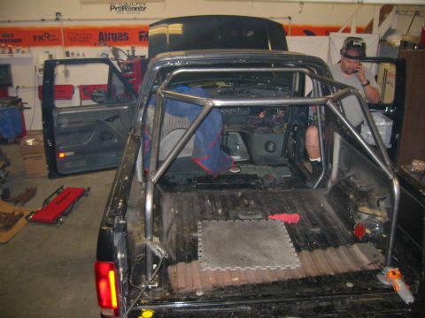 1992 Ford Bronco - This truck is being worked on, with a rollcage installed in the cabin and bed.