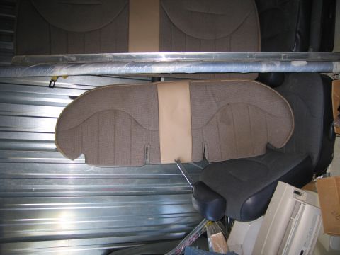 1991 Ford LTD Crown Victoria - Several car seats are stored in a metal-lined space, with one seat back prominently displayed.