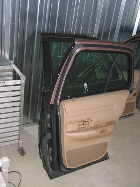 1991 Ford LTD Crown Victoria - A car door with a tan interior panel is shown inside a storage unit.