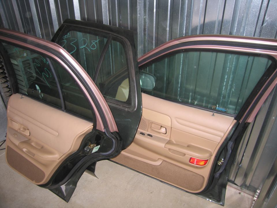 Car doors with tan interior and dark exterior, some writing on the glass