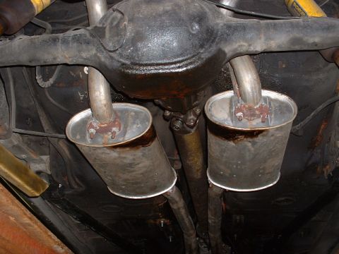 1978 Ford Mustang II - The underside of a vehicle shows a dual exhaust system with mufflers and a differential, with visible oil leaks.