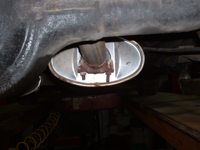 Close-up of a vehicle's exhaust pipe connecting to the muffler