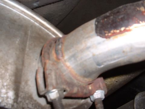 1978 Ford Mustang II - Close-up of a rusted exhaust pipe connection, showing a flange and bolts.