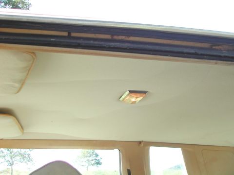 1985 Ford LTD Crown Victoria - Close-up of a car's interior headliner, showing the dome light and sun visors.