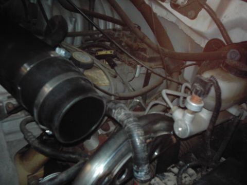 1978 Ford Bronco - Close-up view of engine bay components, including a large intake tube and plumbing.