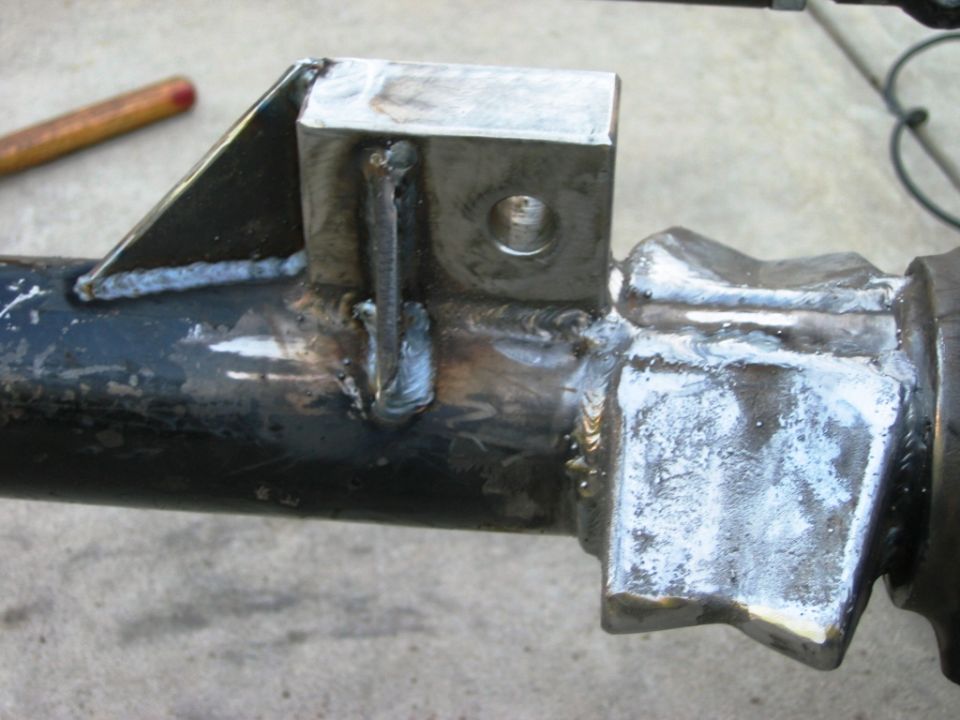 Welded steel bracket with bolt hole and gusset on black axle tube
