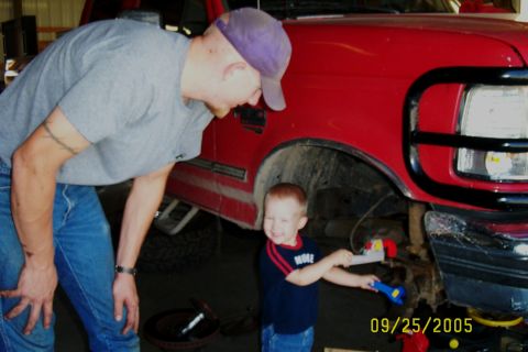 1995 Ford F-350 - Man and child with toy tools near the front of a red 1995 Ford F-350.