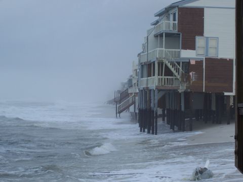 1995 Ford Bronco - Houses on stilts are battered by waves during a storm with limited visibility.