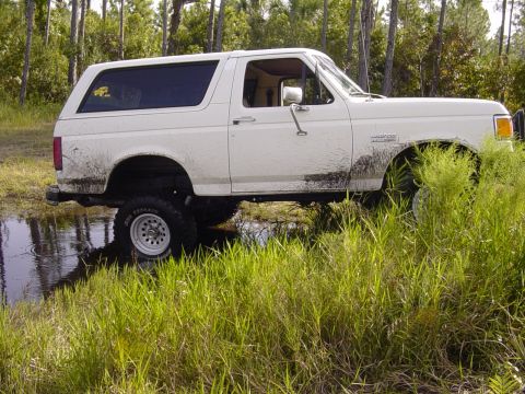 1989 Ford Bronco - White 1989 Ford Bronco covered in mud after driving through a water obstacle.