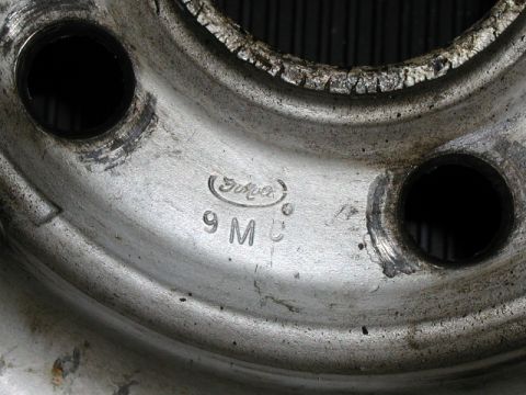1967 Ford Ranchero - Close-up of a Ford wheel rim showing stamped markings and bolt holes.