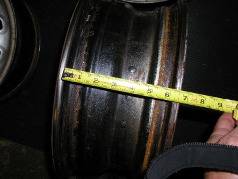1967 Ford Ranchero - Measuring the width of a steel wheel rim with a yellow tape measure.