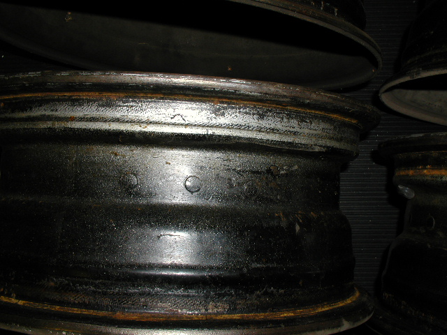 Close-up of rusty bare steel wheel rims stacked on edge