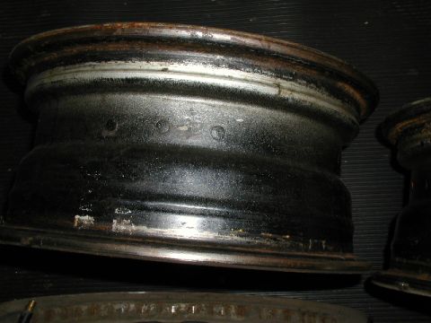 1967 Ford Ranchero - Several old steel wheels are shown in this close-up image, some with visible rust and wear.