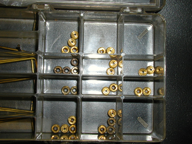 Small brass eyelets, ferrules and pins sorted in a clear parts organizer tray