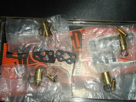 1967 Ford Ranchero - A collection of carburetor components, including gaskets and brass fittings, are displayed in their original packaging.
