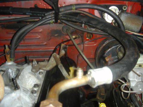 1986 Ford Mustang - Close-up view of the engine bay of a 1986 Ford Mustang, showing various hoses and mechanical parts.
