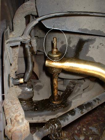 1999 Ford Crown Victoria - A close-up view of a greasy suspension component, likely part of a vehicle's undercarriage.