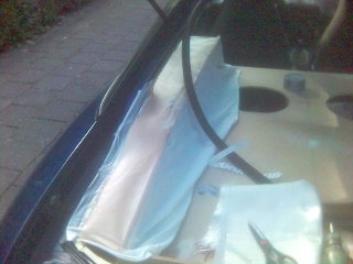 1994 Ford Probe - Insulation is being applied to the engine bay of a vehicle, with a Supermotors logo in the corner.
