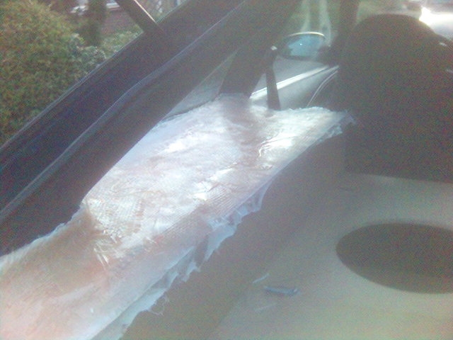 Car dashboard with white material covering the center console area, viewed from the passenger side