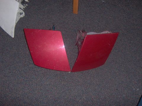 1994 Ford Probe - Two red car fender pieces are shown lying on a carpeted floor.