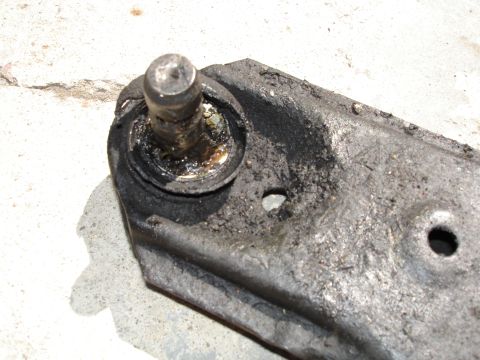 1989 Mazda MX-6 - Close-up of a used suspension part, showing grease and wear on the metal and rubber components.