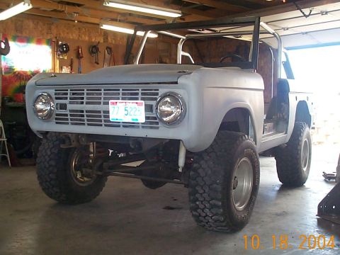 1974 Ford Bronco - Project 1974 Ford Bronco in primer, showing front end and roll cage in garage.