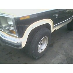 1981 Ford Bronco - Close-up view of the front fender and wheel of a two-tone black and white Ford Bronco.
