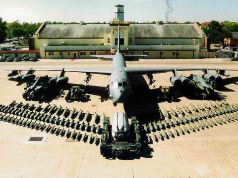 1978 Ford Mustang II - A bomber aircraft is parked on an airfield with many bombs laid out in rows.