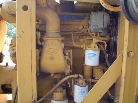 1966 International School Bus - Close-up view of yellow engine components including an alternator and fuel filters.