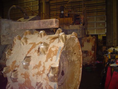 1966 International School Bus - Close-up of a compactor's spiked roller drum, showing wear and tear.