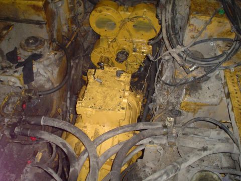 1966 International School Bus - Close-up view of heavy machinery engine and transmission parts with hydraulic lines.
