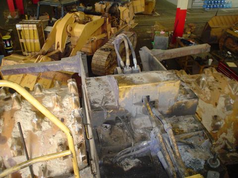 1966 International School Bus - Multiple pieces of heavy construction equipment are visible in this workshop setting.