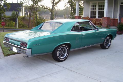 1967 Pontiac Lemans - Rear three-quarter view of a teal coupe parked on a concrete driveway.