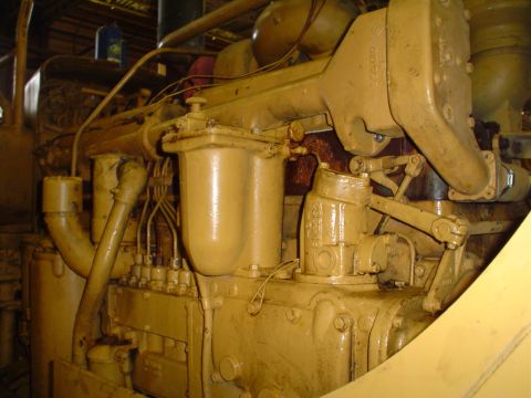 1966 International School Bus - This is a close-up view of a large, yellow engine, possibly from industrial machinery.