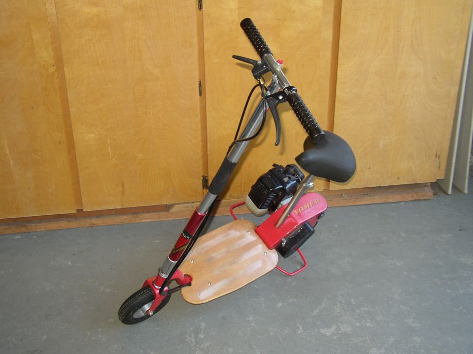 Red and silver motorized scooter with a wooden deck and black seat