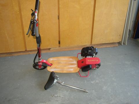 1987 Volkswagen Golf - A red motorized scooter with a Yomer engine and a detached seat is shown disassembled on a concrete floor.