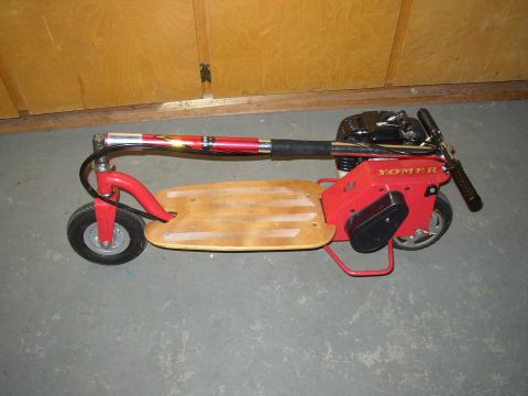 1987 Volkswagen Golf - This motorized scooter has a wooden deck and red frame, with YOMER branding visible.