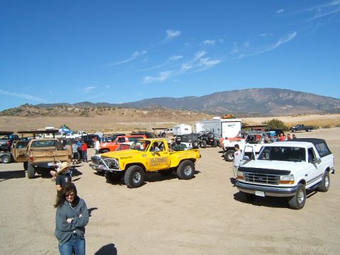 1988 Ford Bronco - A white Ford Bronco is parked with other vehicles under a clear blue sky.