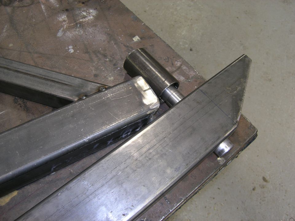 Metal bumper components on a workbench, showing welded joints and a cylindrical attachment