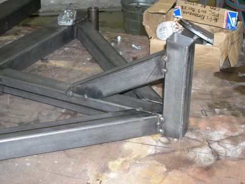 2001 Jeep Wrangler - A metal frame assembly is shown on a workbench, with a small toy car placed on its structure.