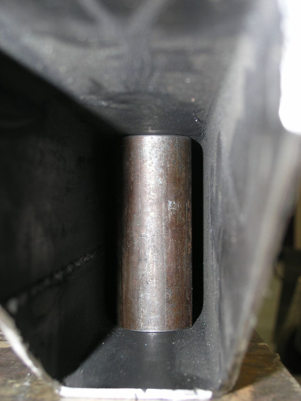 Close-up of a metal cylinder inserted into a dark, rectangular frame