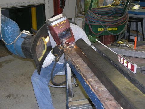 2001 Jeep Wrangler - Metal fabrication in progress: a welder joins two steel beams in a workshop environment.