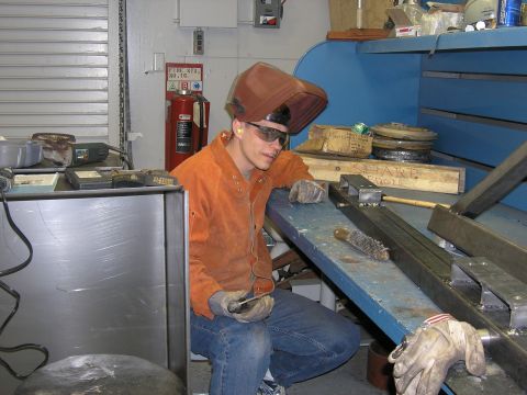 2001 Jeep Wrangler - A person in protective gear works in a workshop environment with various tools and materials.