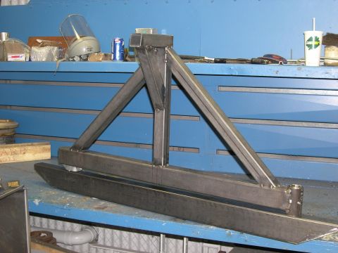 2001 Jeep Wrangler - A custom-fabricated metal bumper assembly is shown, likely for an off-road vehicle, resting on a blue workbench.