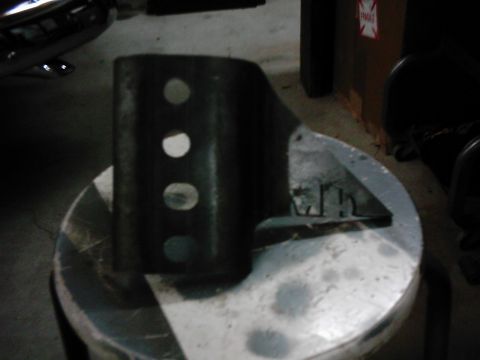1978 Ford Bronco - A close-up view of a metal bracket with multiple holes, likely a vehicle part.