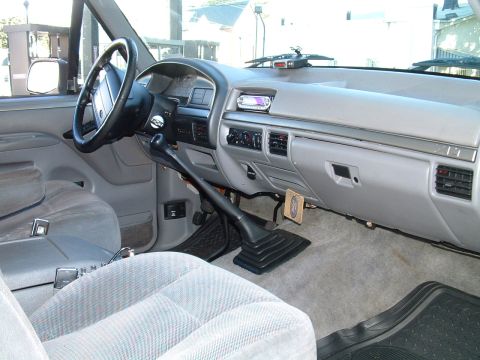 1994 Ford Bronco - The interior of a truck features a manual transmission shifter and gray cloth seats.