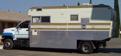 1995 Ford Bronco - This motorhome is parked on the side of a street, showing its full length from the side view.