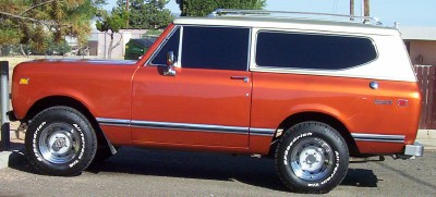 1995 Ford Bronco - This orange and white SUV is shown from the side.