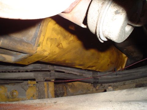 1966 International School Bus - A close-up view shows a yellow oil filter and part of an exhaust system, likely from a truck or heavy equipment.